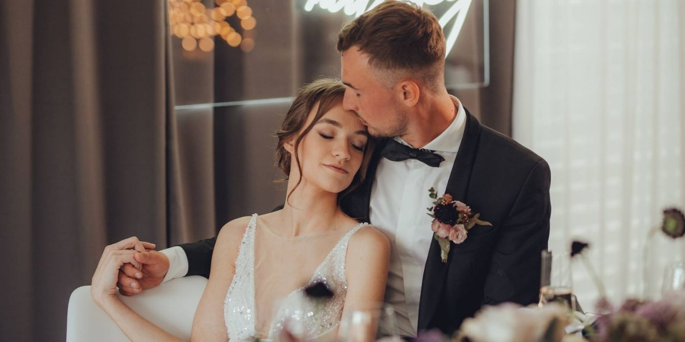 novomanžeslký pár elegantní sedící u svatebního stolu