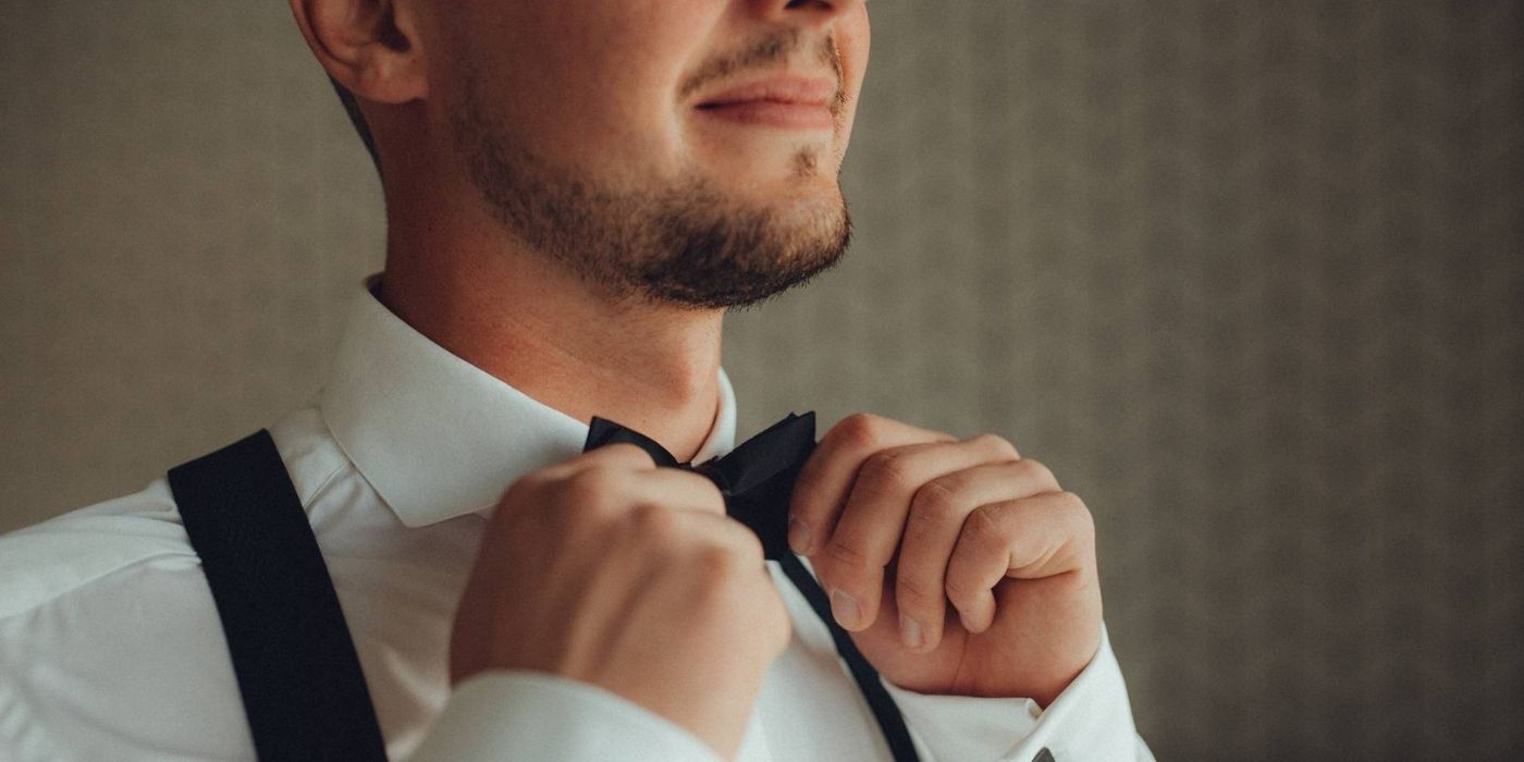 ženich držící motýlek při přípravách na svatbu