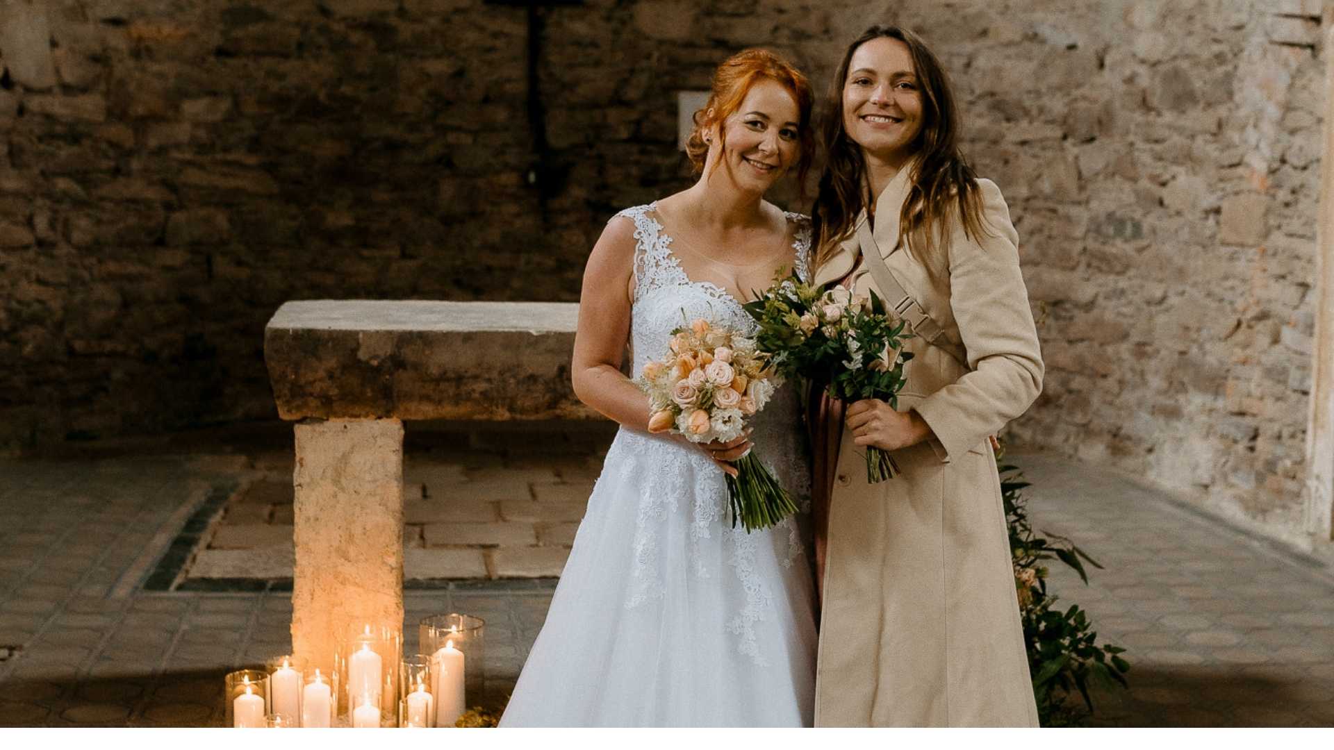 nevesta se svedkyni a kyticemi v historickem kostele u obradniho mista