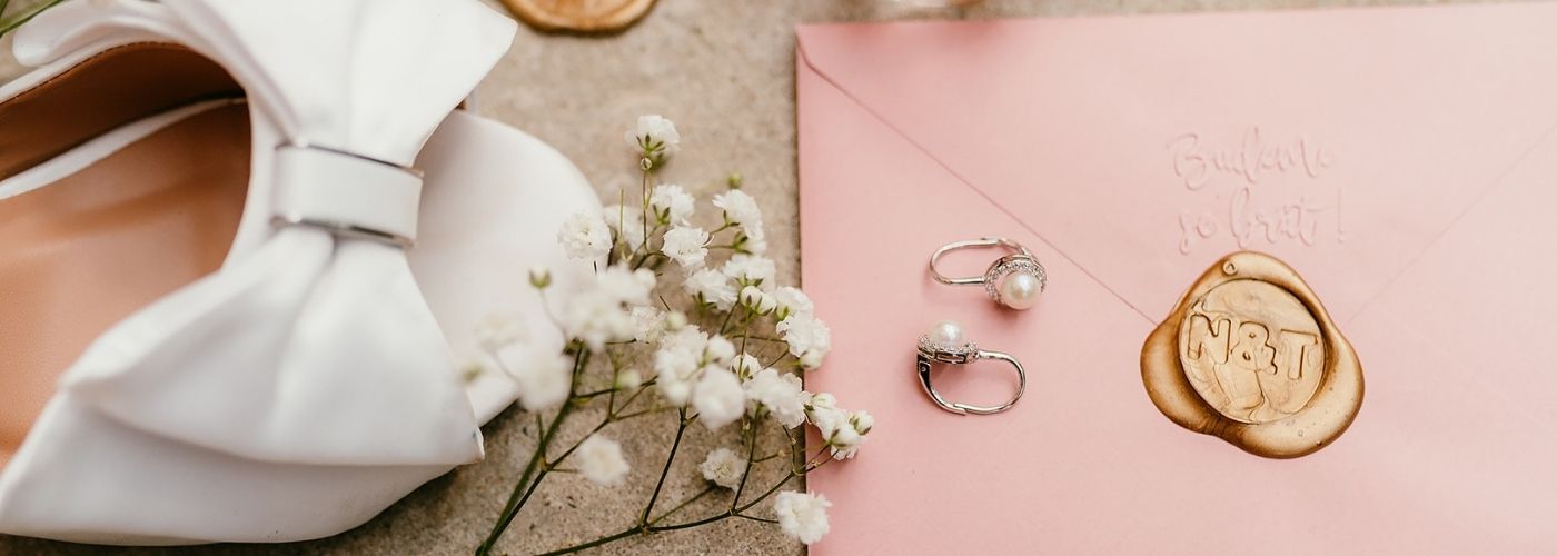 detaily nevěstiny boty, naušnic a obálky ze svatebního oznámení