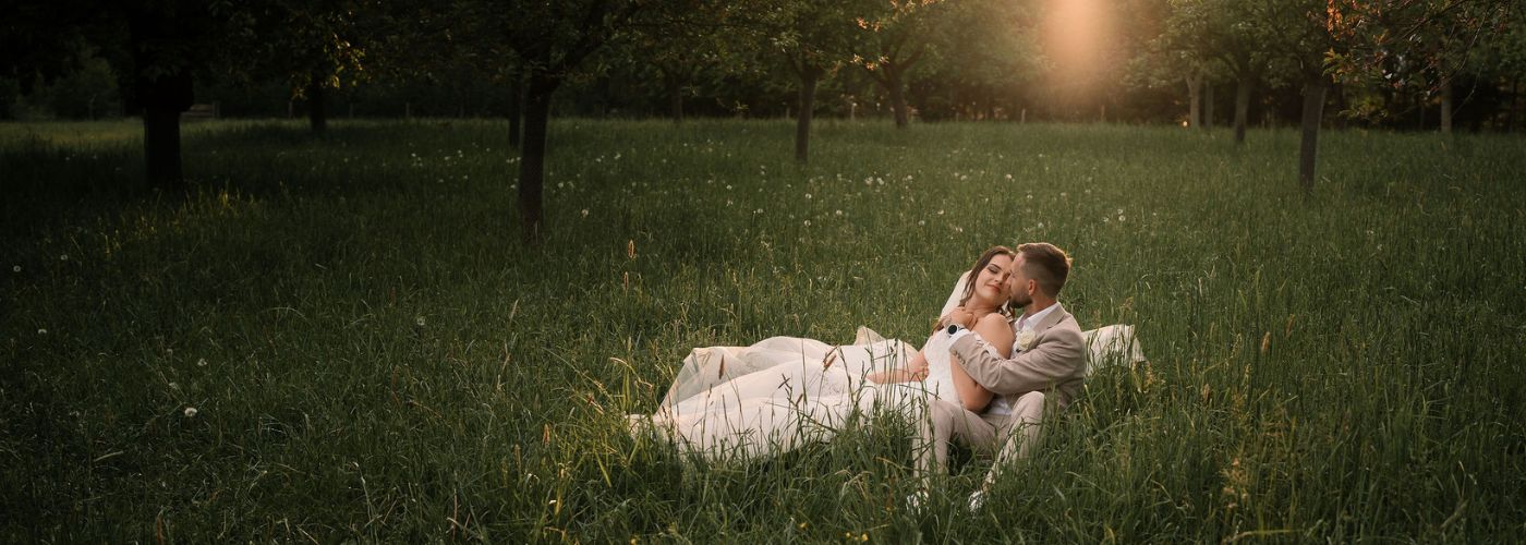 novomanželé sedící v trávě